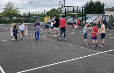 Children and adults on tennis court
