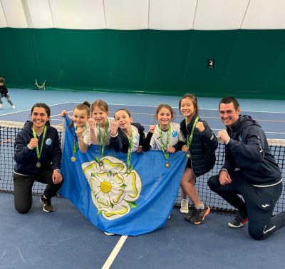 Girls and tennis coaches with Yorkshire flag
