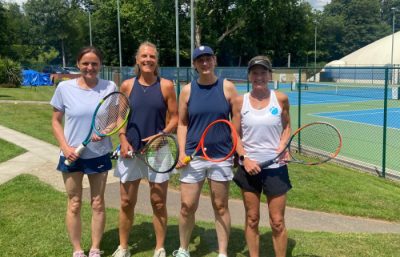 Four women holding tennis rackets at tennis club