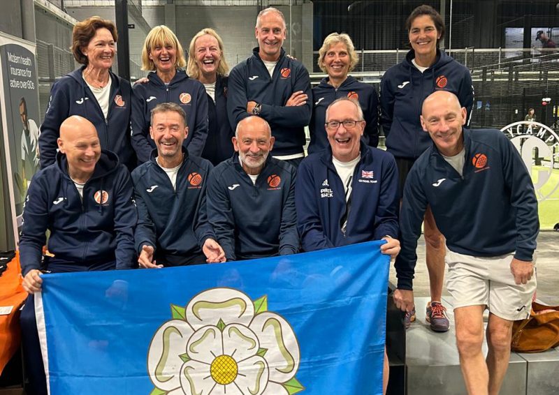Men and women behind flag on padel court