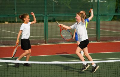 Girls playing on tennis court